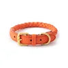Orange braided dog collar with a gold buckle on a white background