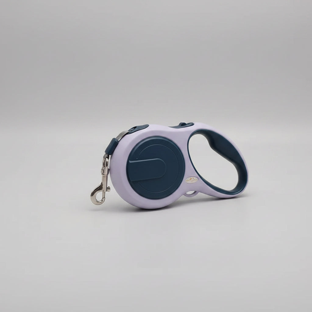Retractable dog leash with purple handle and blue reel on a white surface with white fabric.