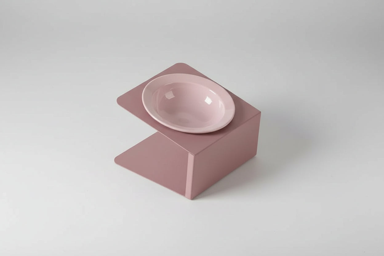 Pink ceramic bowl on a matching pink stand with a small icon and text on a light purple background.