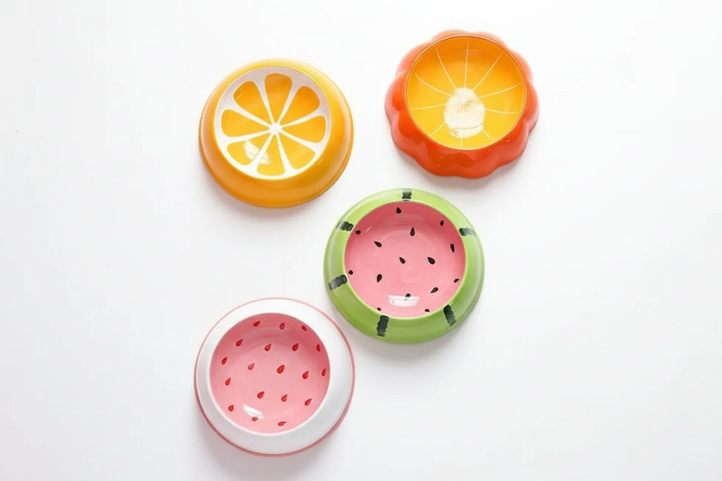 Set of colorful fruit-themed bowls on a beige background