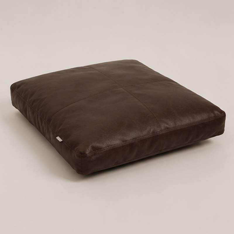 Minimal leather pet bed in espresso brown with soft structured cushion design on neutral background.