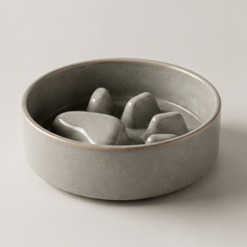 Gray ceramic bowl with abstract stone-like sculptures on a light gray background