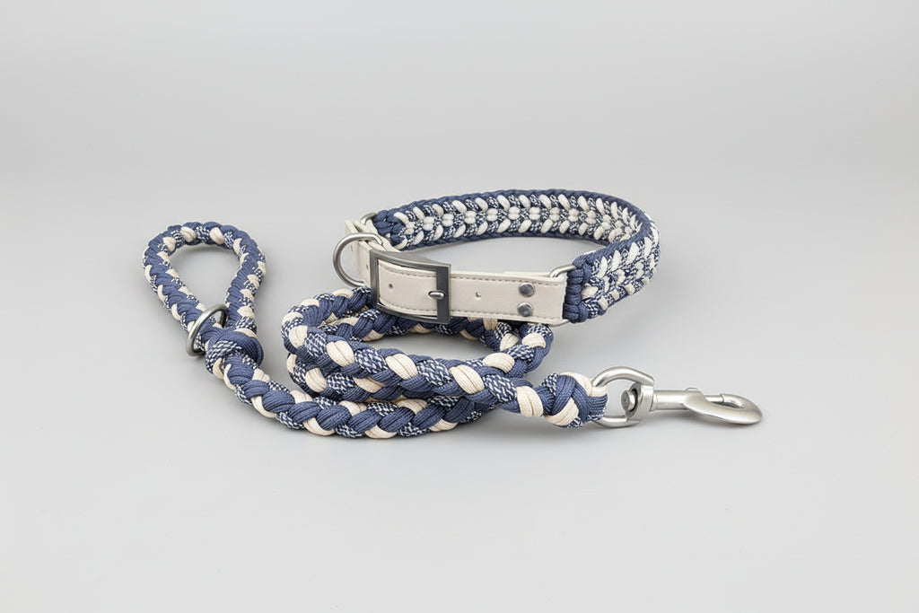 Blue and white braided dog leash with metal clip on a wooden surface